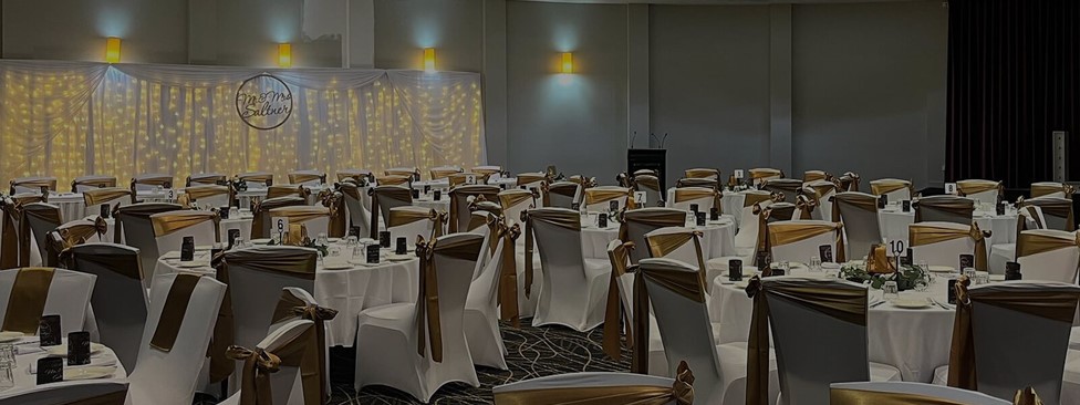 Indoor wedding reception set up with fairy lights and gold and white detailing