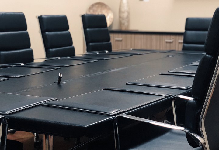 Close up of black leather boardroom table and chairs for business meetings