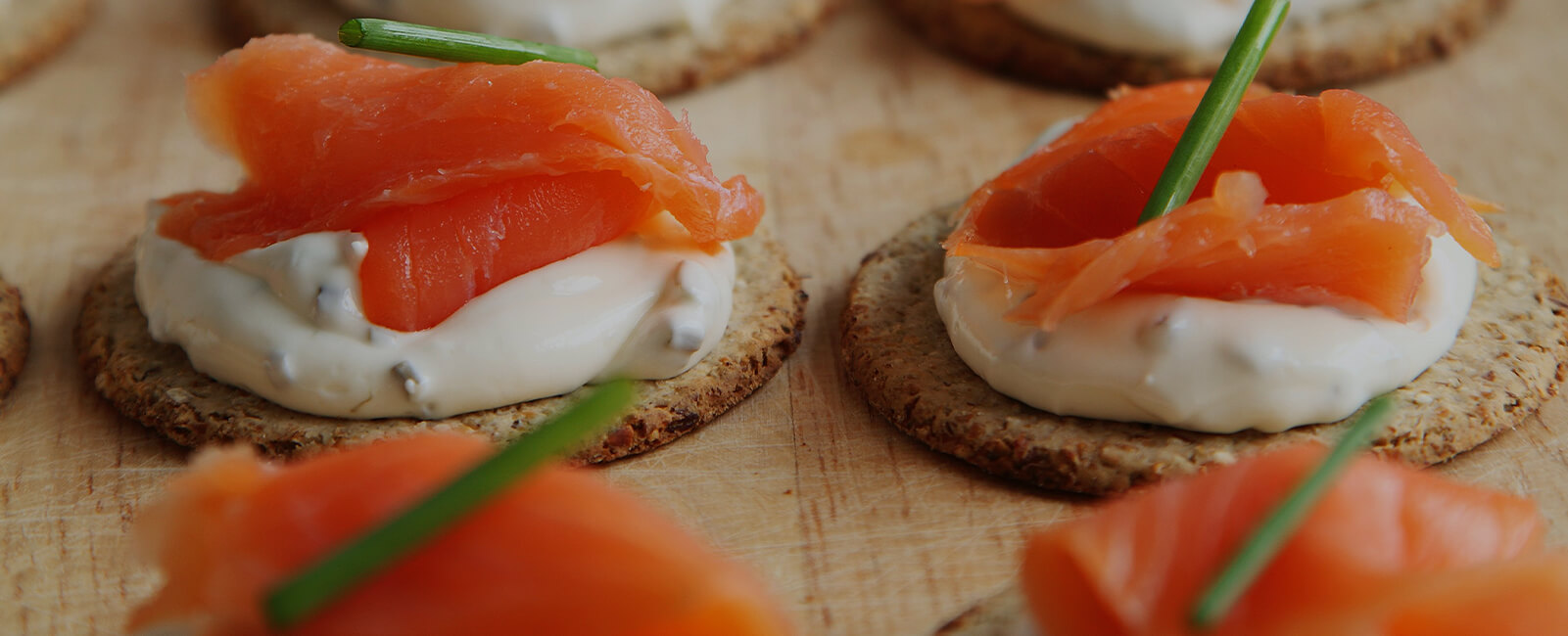 Close up of salmon and sauce on crackers for event catering