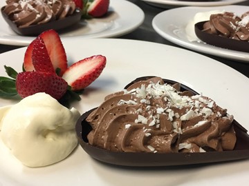 Plates with chocolate heart full of chocolate mousse with ice-cream and strawberry on side