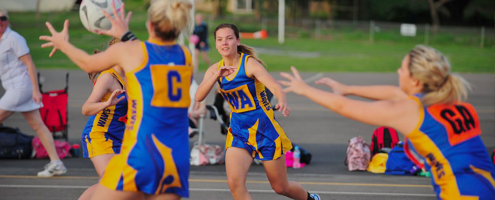 Women playing netball mid throw