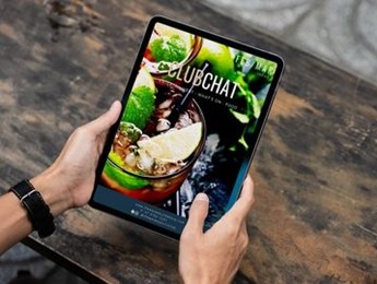 Hands holding tablet with the latest ClubChat open