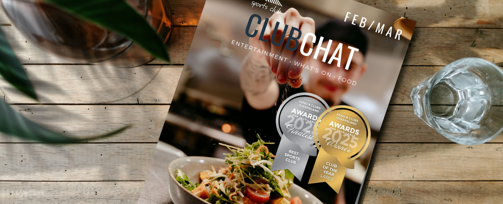 Hands holding tablet device with ClubChat magazine on screen