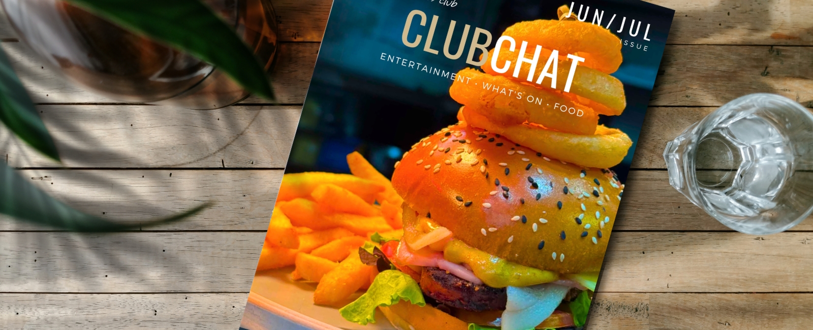 Hands holding tablet device with ClubChat magazine on screen